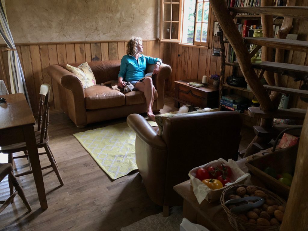 Kate Humble sitting on her Indigo Grandad sofa with Bella at Poachers Cabin